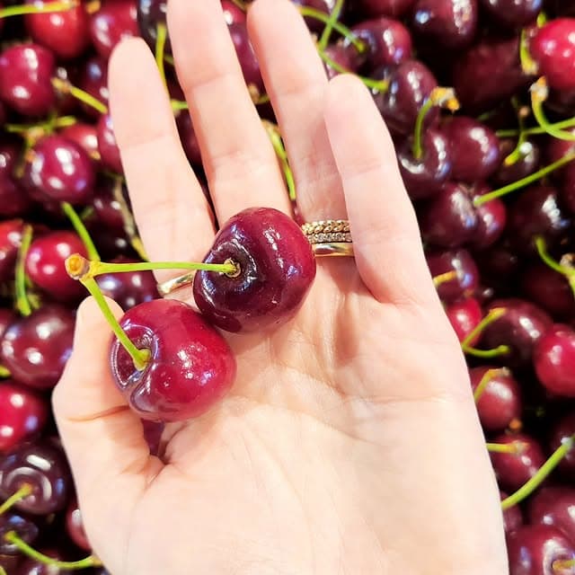 כף ידה של הילו אוחזת דובדבנים טריים